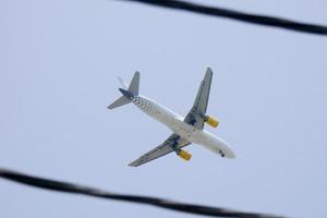 kommersiell flygplan flygande under blå himmel och anländer på de flygplats foto