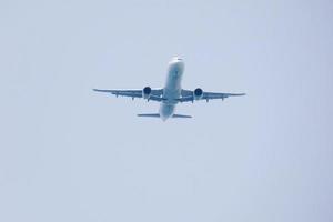 kommersiell flygplan flygande under blå himmel och anländer på de flygplats foto