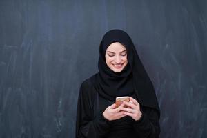 ung modern muslim företag kvinna använder sig av smartphone foto