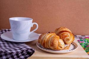 kopp av kaffe och croissant foto