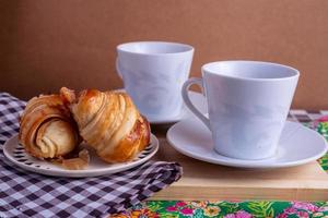 kopp av kaffe och croissant foto