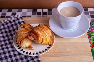 kopp av kaffe och croissant foto