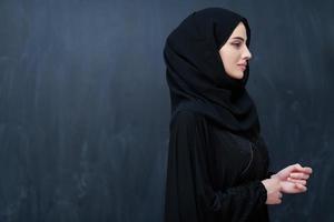 modern ung muslim kvinna i svart abaya foto