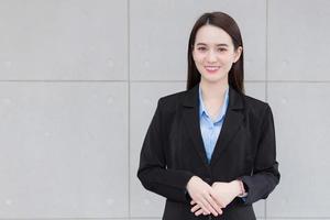 asiatisk företag arbetssätt kvinna står och ler lyckligt i arbetsplats. foto