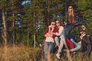 grupp ung Lycklig människor njuter skön solig dag medan körning en av väg buggy bil foto