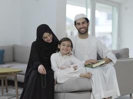 ung muslim familj läsning quran under ramadan foto