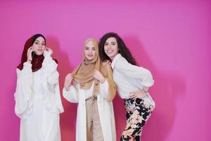 muslim kvinnor i modern klänning isolerat på rosa foto