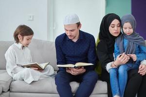 ung muslim familj läsning quran under ramadan foto