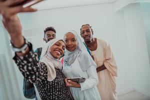 en grupp av multietnisk studenter ta en selfie med en smartphone på en vit bakgrund. selektiv fokus foto