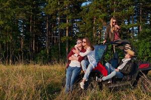 grupp ung Lycklig människor njuter skön solig dag medan körning en av väg buggy bil foto