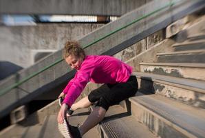 kvinna stretching innan morgon- joggning foto