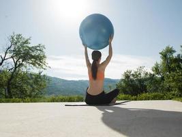 kvinna håller på med övning med pilates boll foto