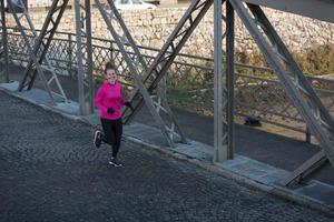 sportig kvinna joggning på morgon- foto