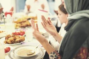 modern multietnisk muslim familj bön- innan har iftar middag foto