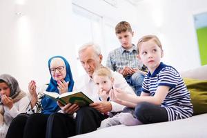 modern muslim farföräldrar med barnbarn läsning quran foto