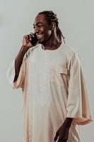 afrikansk man använder sig av smartphone och bär traditionell sudan kläder. foto