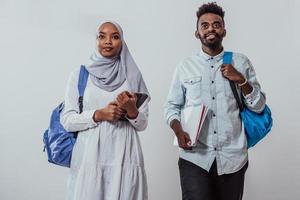 ung afrikansk studenter par gående kvinna bär traditionell sudan muslim hijab kläder företag team isolerat på vit bakgrund. hög kvalitet Foto