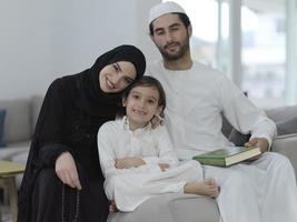 ung muslim familj läsning quran under ramadan foto