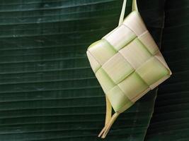 isolerat. tömma Ketupat har inte varit fylld med ris. i Indonesien, den ofta visas innan de firande av eid al-fitr efter ramadan. design begrepp, mörk grön bakgrund. foto