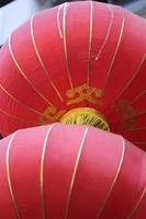 två röd kinesisk lyktor hängande i chinatown. foto
