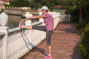 kvinna stretching innan morgon- joggning foto