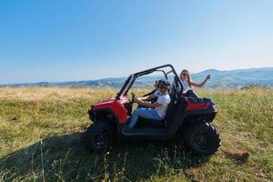 grupp ung Lycklig människor njuter skön solig dag medan körning en av väg buggy bil foto