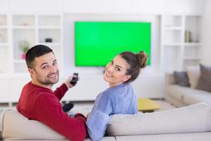 ungt par på soffan tittar på tv foto