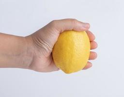 hand kvinna innehav mogen citron- isolerat foto