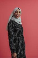 porträtt av ung modern muslim skönhet bär traditionell islamic kläder på plast rosa bakgrund. selektiv fokus foto
