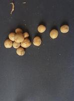 små potatisar på en svart tabell. foto