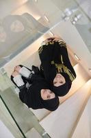 topp se av två muslim flickor bär svart abaya foto