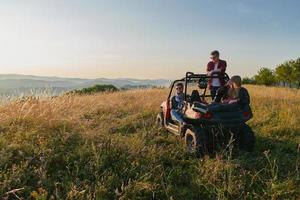 grupp ung Lycklig människor njuter skön solig dag medan körning en av väg buggy bil foto