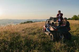 grupp ung Lycklig människor njuter skön solig dag medan körning en av väg buggy bil foto