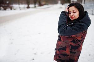 yong asiatisk kvinna ha på sig jacka med handväska i kall vinter- dag. foto