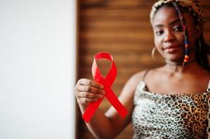 AIDS medvetenhet. eleganta afrikansk amerikan kvinna håll röd band. foto