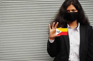 asiatisk kvinna på formell ha på sig och svart skydda ansikte mask håll marquesas öar flagga på hand mot grå bakgrund. coronavirus på Land begrepp. foto