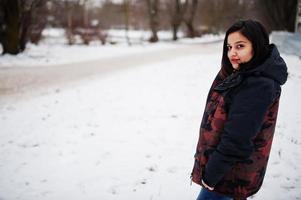 yong asiatisk kvinna ha på sig jacka med handväska i kall vinter- dag. foto