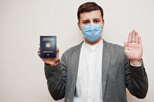 europeisk man i formell ha på sig och ansikte mask, visa liechtenstein pass med sluta tecken hand. coronavirus låsning i Europa Land begrepp. foto