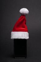 smartphone med santa hatt som jul närvarande foto