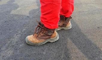 friska säkerhet och miljö- kommenderar vem ha på sig röd byxor uniformer och brun säkerhet skor. foto