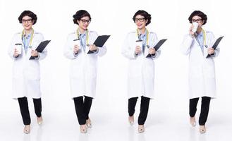 full längd 30s 40s asiatisk kvinna läkare med stetoskop, gående framåt- vänster höger, ha på sig formell täcka flämta skor. leende sjukhus kvinna bära patient Diagram kaffe kopp över vit bakgrund isolerat foto