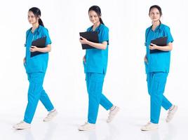 full längd 20s ung blanda lopp sjukhus sjuksköterska kvinna, gående framåt- vänster rätt steg, ha på sig stetoskop blå enhetlig. läkare kvinna känner leende Lycklig över vit bakgrund isolerat foto