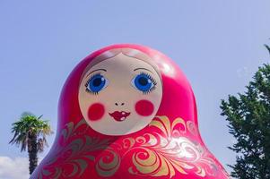 jätte ryska matrioshka docka på de backgound av blå himmel och handflatan träd foto