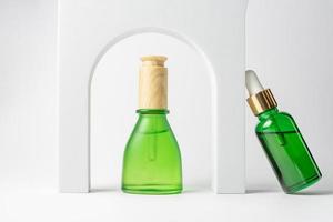 uppsättning av naturlig skönhet olja för hud vård i grön dropper flaskor witb vit pallplatser. trendig attrapp för kosmetika presentation. ört- organisk kosmetika foto