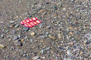 kvinnas flip flops på de sten strand. kopia Plats. turism och semester begrepp foto