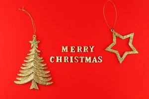 festlig hälsning kort. glad jul text på röd bakgrund med gyllene glittrande stjärna. foto