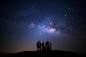 landskap med mjölkig sätt, natt himmel med stjärnor och silhuett av Lycklig man stående på hög moutain foto