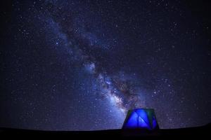 landskap med mjölkig sätt galax, starry natt himmel med stjärnor och silhuett av kupol tält foto