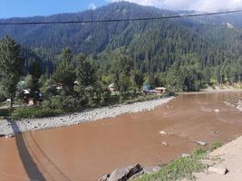 kashmir är de mest skön område i de värld som är känd för dess grön dalar, skön träd, hög bergen och strömmande fjädrar. foto