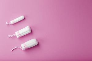 bomull tamponger på en rosa bakgrund med en fri Plats foto